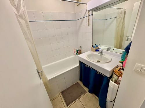 Salle de bain moderne aux carreaux blancs, vasque bleue ronde, baignoire et douche dans un appartement du centre d'Aix-en-Provence