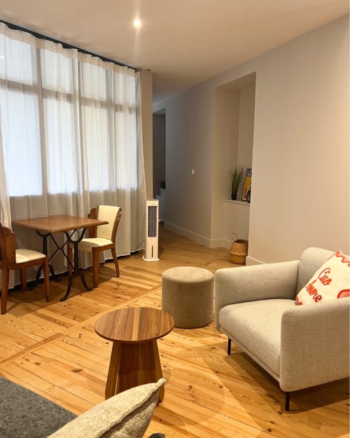 Lumineux séjour avec parquet, canapé beige, table basse ronde et coin salle à manger à l'appartement Kipling House