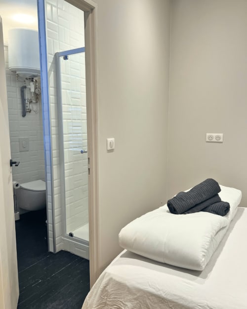 Chambre compacte à la Maison Kipling avec lit, serviettes foncées, salle de bain privée et équipements modernes