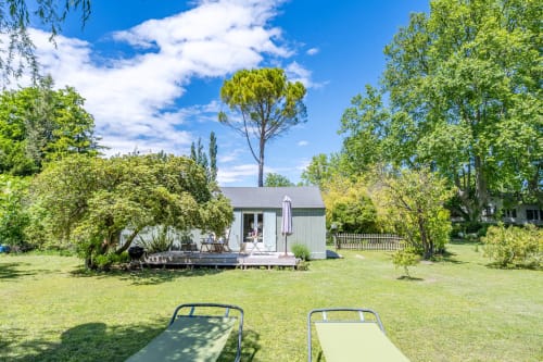 Cottage Le Cabanon avec coin détente en jardin à Locations Montjoïa Provence, Le Thor, entouré de verdure et pelouse luxuriante