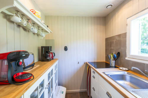 Petite kitchenette du gîte Le Cabanon à Locations Montjoïa Provence avec cafetière rouge, comptoirs en bois et évier