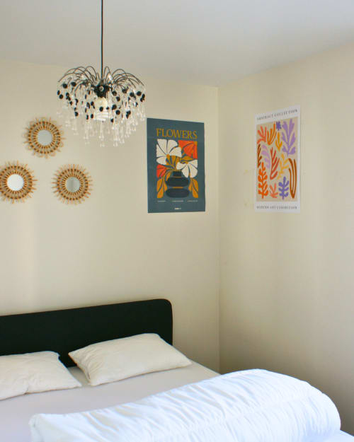 Chambre moderne à Kipling House avec lit noir, luminaire suspendu, art mural et motifs géométriques