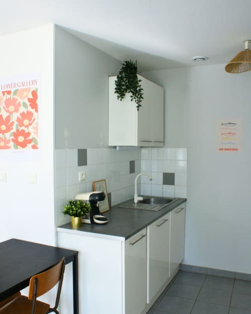 Kitchenette moderne à Kipling House avec armoires blanches, plan de travail foncé et table à manger à Saint Beauzire, France