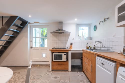 Cuisine moderne du gîte Le Gîte bleu aux Locations Montjoïa Provence au Thor, avec meubles en bois, cuisinière à gaz et blanc