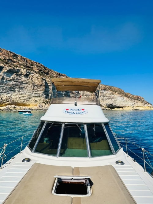 Lussuoso motoscafo 'Piccola Grande Amore' ancorato nelle acque turchesi davanti alle scogliere spettacolari di Lampedusa