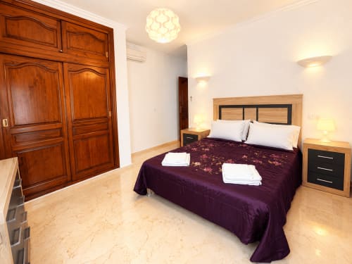 Espacioso dormitorio en villa Casa Jonur, Moraira, con cama queen, armario de madera y piso de mármol