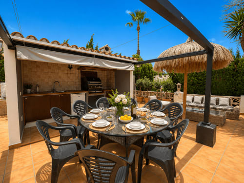 Terraza de villa en Moraira con comedor al aire libre, cocina, parrilla y sombrilla de paja