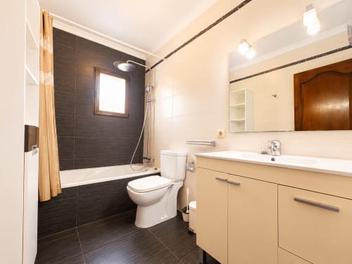 Baño moderno en villa Casa Jonur con ducha de azulejos negros, tocador beige y accesorios contemporáneos en Moraira