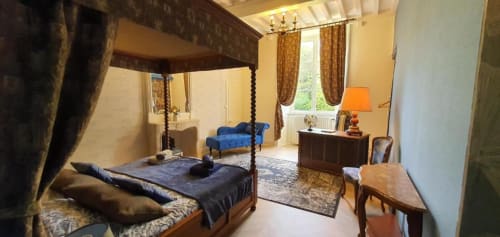 Suite luxueuse 2 chambres au Manoir de Saint-Ouen avec lit à baldaquin, sièges bleus et vue sur le jardin