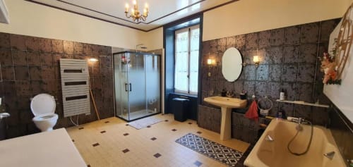 Salle de bains spacieuse de luxe au Manoir de Saint-Ouen avec carrelage foncé, douche séparée, baignoire, vue sur le jardin