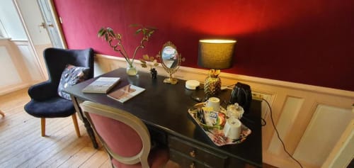 Élégant bureau d'hôtel au Manoir de Saint-Ouen avec murs rouges, bureau noir et mobilier classique à Sideville