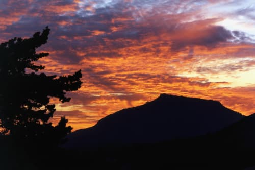 Tramonto spettacolare sulle montagne vicino all'Hotel Candalú, Valderice Sicilia con alberi sagomati e nuvole dorate