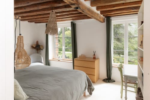 Chambre rustique aux Lodges de la Ferme de la Chaise avec poutres apparentes, luminaire suspendu tissé et vue sur la campagne