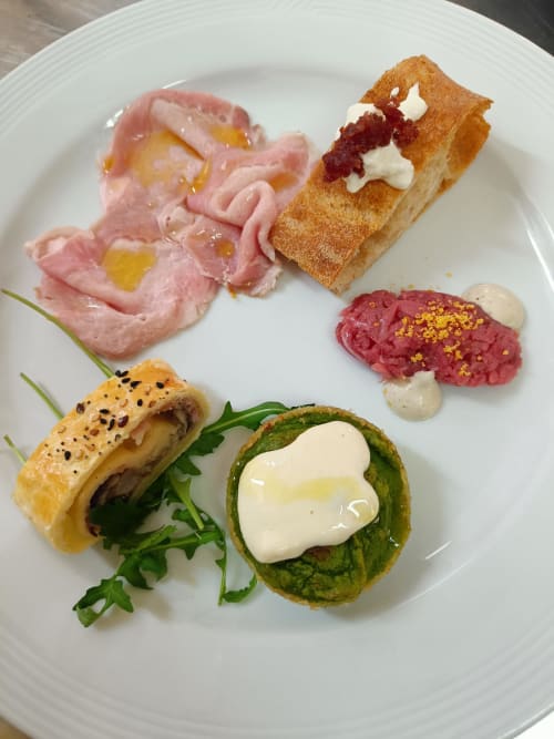 Elegant plated appetizers at Hotel Ristorante alle Querce in Castelbuono featuring cured meats, artisan bread, and