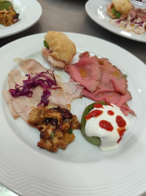 Elegant plated charcuterie and appetizers at Hotel Ristorante alle Querce in Castelbuono, featuring cured meats, burrata, and