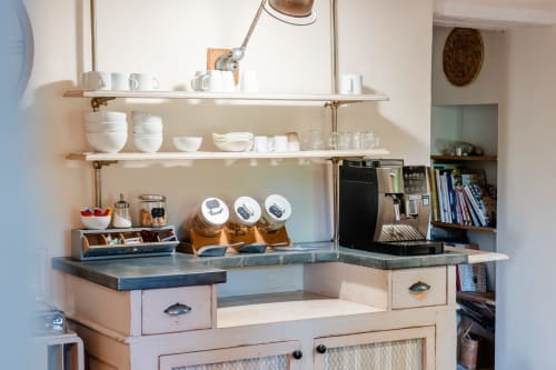 Coin cuisine élégant avec étagères ouvertes, vaisselle blanche, cafetière et rangements à Locations Montjoïa Provence