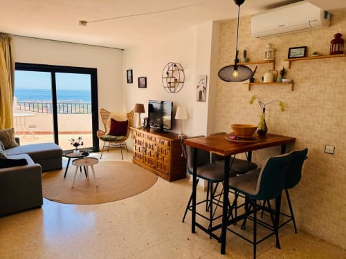Moderno apartamento en Nerja con vistas al mar, zona de comedor, sala de estar y cocina equipada