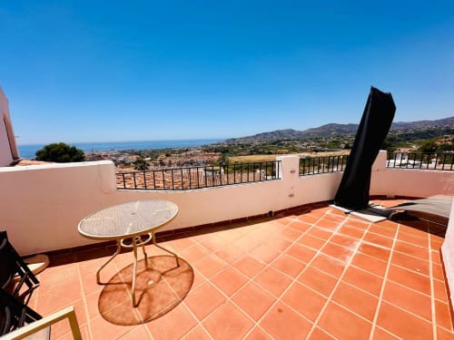 Terraza con vistas al mar del apartamento Nerja Holiday Homes, con baldosas de terracota, barandillas blancas y estilo mediterráneo