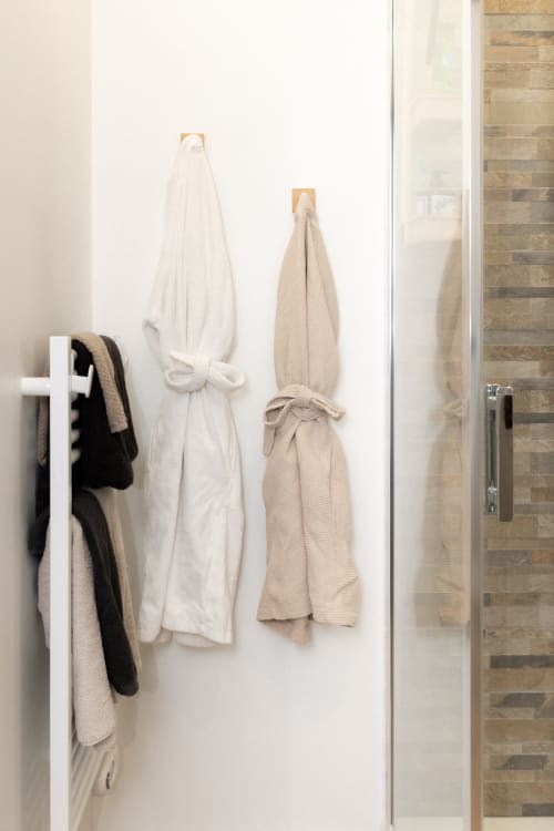 Porte-serviettes de salle de bain avec peignoirs blancs et serviettes beige, Chambre Cerf aux Lodges de la Ferme de la Chaise