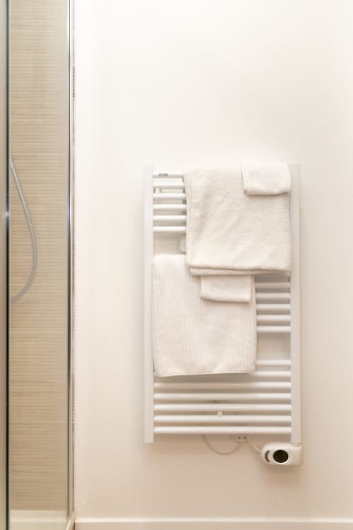 Porte-serviettes chauffant blanc avec serviettes moelleuses à la Chambre Mouton, Lodges de la Ferme de la Chaise, Saint-Antonin-de-Sommaire