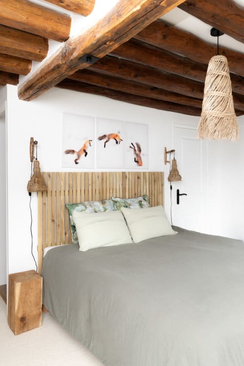 Chambre rustique aux Lodges de la Ferme de la Chaise avec plafond à poutres, tête de lit ardoisée et œuvre d'art renard
