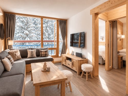 Élégant séjour avec vue sur les montagnes enneigées, poutres en bois et mobilier contemporain à Arc 1800