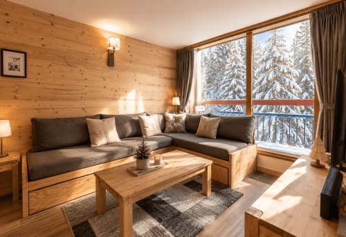Salon lumineux du chalet en bois avec vue alpine enneigée, canapé d'angle, cheminée à Arc 1800