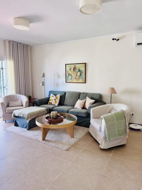 Luminosa sala de estar de villa en Nerja con mobiliario moderno, cómodos asientos, mesa de madera y acceso a vistas al mar