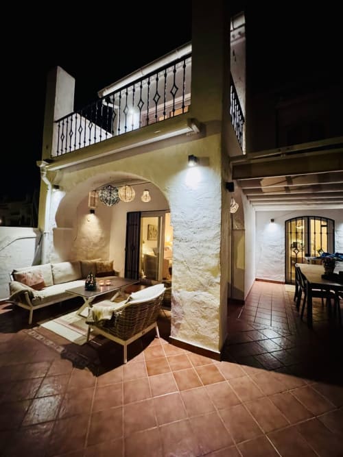 Villa de Nerja con patio nocturno, zona de descanso, entrada abovedada y balcón con vista al patio