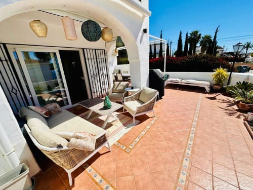 Soleada terraza de acogedora villa en Nerja con tumbonas, vista al mar y paisajismo mediterráneo