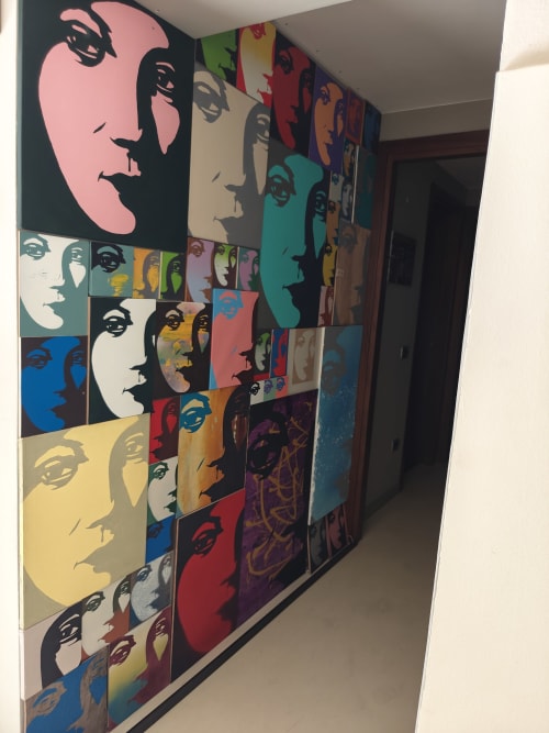 Griglia di ritratti in stile pop art nella suite Coco's Home dell'hotel di Cesena, con volti astratti colorati sulla decorazione murale