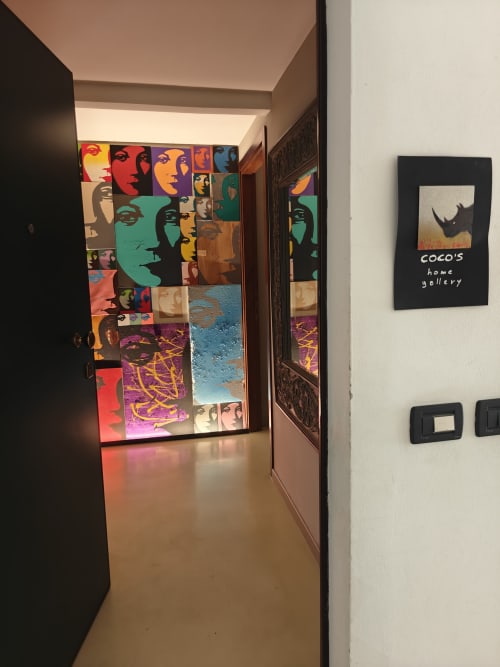 Ingresso della galleria Coco's Home con ritratti pop art colorati e installazioni astratte nell'appartamento di Cesena