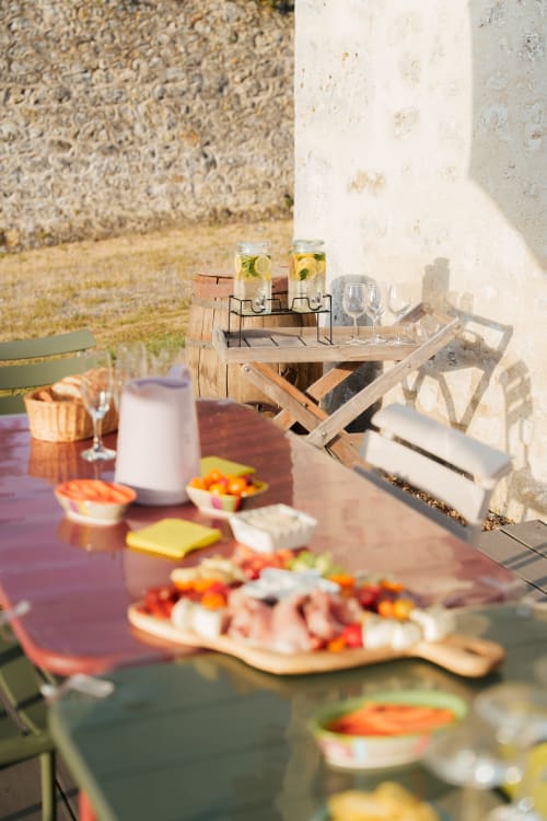 Table dressée en plein air au Hameau de Céline avec entrées, boissons rafraîchissantes et charme rustique de la campagne française