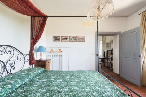 Appartamento Pietro a Borgo Rinascimento a Farnese, Italia, con letto in ferro ornamentale, biancheria botanica verde e rosso