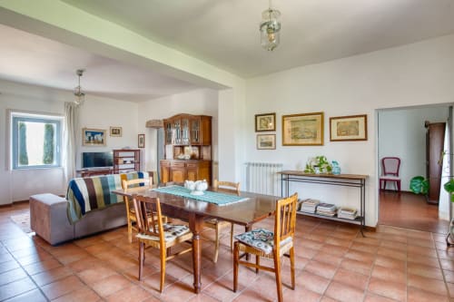 Appartamento Pietro a Borgo Rinascimento a Farnese con tavolo da pranzo, sedie in legno, divano e pavimenti in terracotta