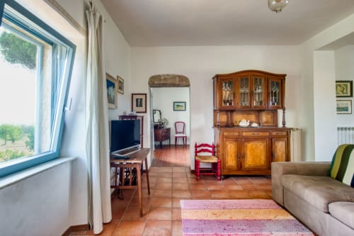 Luminosa camera da letto nell'appartamento Pietro a Borgo Rinascimento, Farnese con pavimenti in terracotta, mobili in legno e ampie finestre