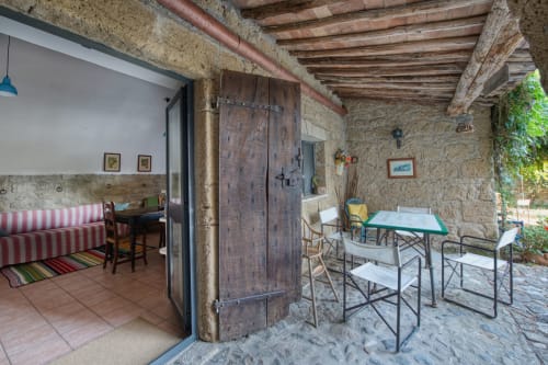L'appartamento La Scuderia a Borgo Rinascimento a Farnese, Italia - patio rustico con muri in pietra, travi in legno, tavolo da pranzo e