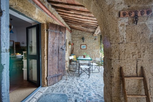 Appartamento La Scuderia a Borgo Rinascimento a Farnese, Italia - suggestiva corte in pietra con tavolo da pranzo e travi in legno