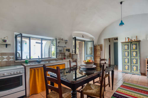 Zona cucina-soggiorno dell'appartamento La Scuderia a Borgo Rinascimento, Farnese con soffitti a volta, porte con cornice blu e