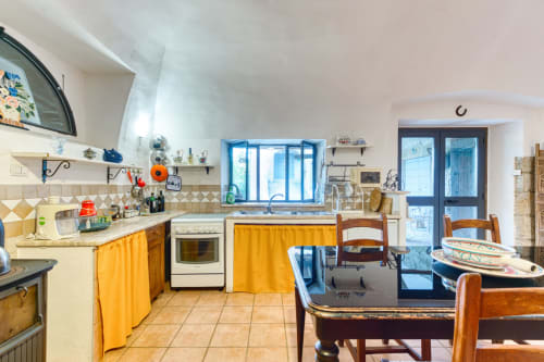 La cucina-sala da pranzo Scuderia a Borgo Rinascimento, Farnese, con dettagli gialli e arredamento rustico in legno