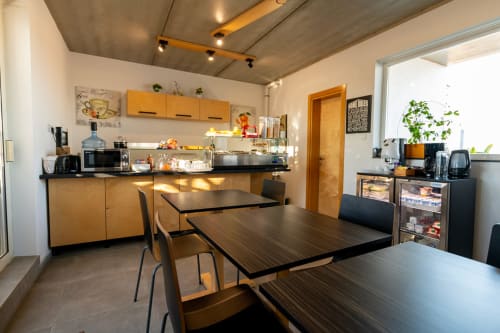 Modern kitchen and dining area in Estrella Lodging Standard Triple Room, Rabat, with wooden cabinets, dining tables, and city