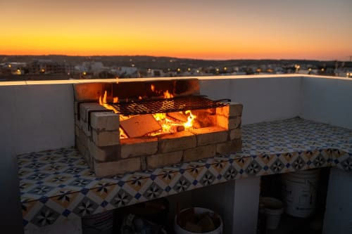 Rooftop fire pit at Estrella Lodging in Rabat with city skyline at sunset
