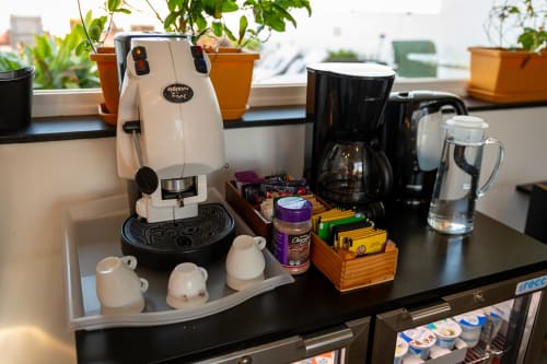 Coffee and beverage station at Estrella Lodging hotel room in Rabat with espresso machine, coffee maker, and tea supplies on
