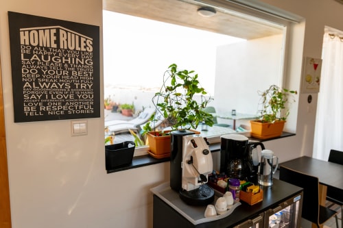 Cozy hotel room kitchenette at Estrella Lodging Rabat with coffee maker, plants, and city view terrace access