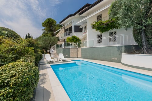 Casa Alba Apartment in Prince Garda, Gardone Riviera mit blauem Swimmingpool, gepflegtem Garten und moderner weißer Villa