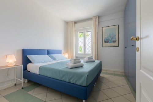 Modernes Schlafzimmer im Casa Alba, Hotel Prince Garda in Gardone Riviera mit blauem Bett, Seefenster und zeitgenössischer Einrichtung