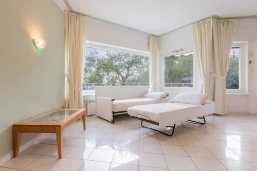 Helles modernes Apartment am Prince Garda mit Einzelbetten, Seefenster, cremefarbener Einrichtung und Fliesenboden in Gardone