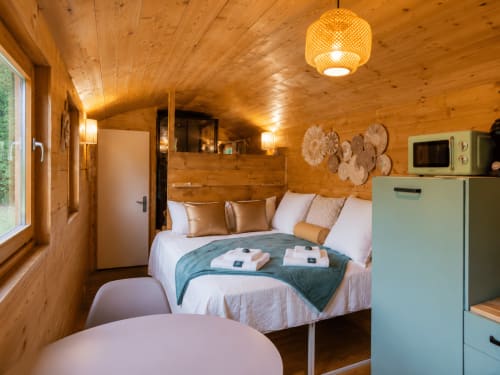 Chambre douillette au chalet en bois avec lit queen, kitchenette turquoise et vue sur les montagnes au Refuge Cévenol à Concoules