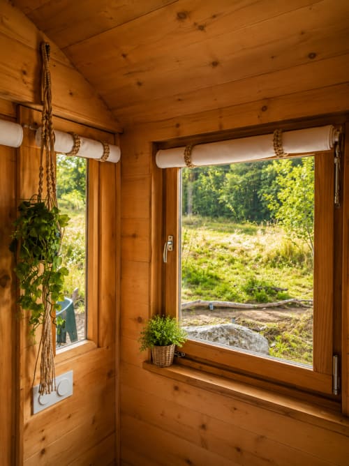 Intérieur de chalet en bois avec fenêtres ouvertes sur le paysage montagneux boisé et la vallée fluviale près de Villefort, Cévennes.