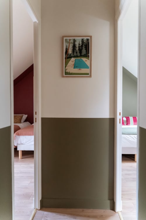 Couloir de la chambre d'hôtes Maisons Noisette avec chambres twin, œuvre d'art bassin forestier et lambris vert sauge